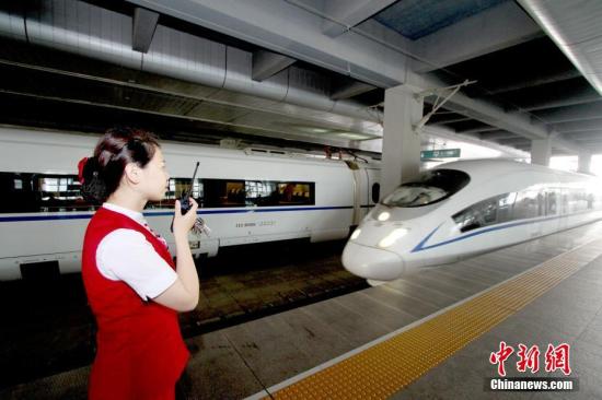 资料图：天津站高铁工作人员迎接入站的京津城际列车。中新社记者 张道正 摄