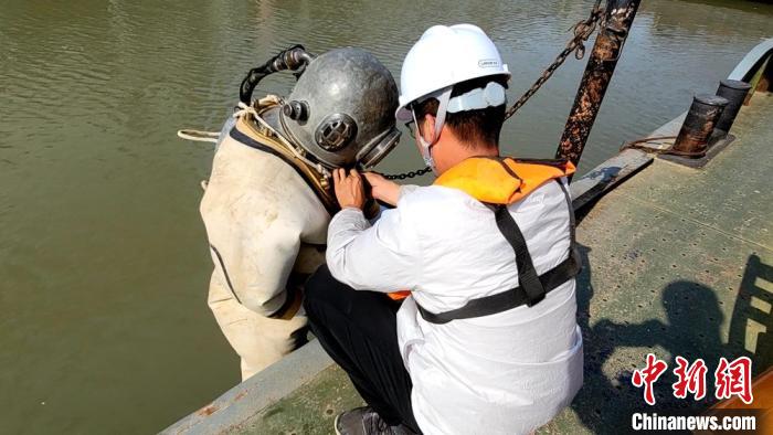 工作人员为准备下潜蛙人检查氧气设备。　陈秋雨 摄